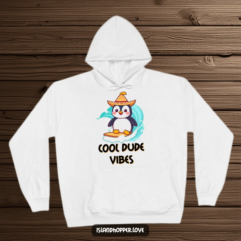 Funny Hoodie: A happy penguin in a tiny sombrero surfs a turquoise wave, bringing warmth and humor.